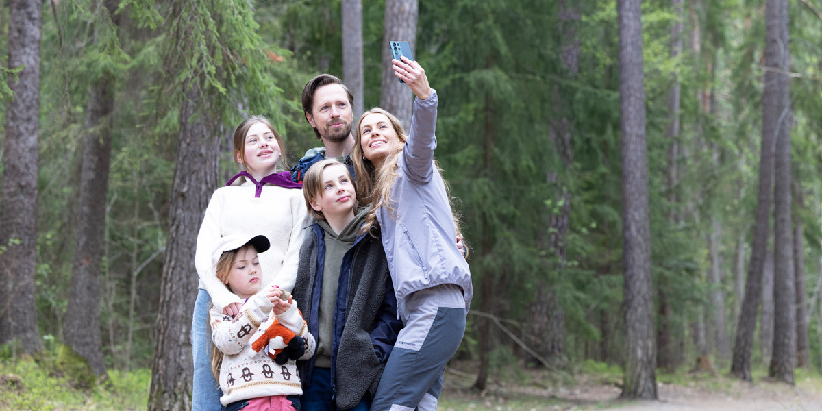 Familie på tur i skogen som tar selfie
